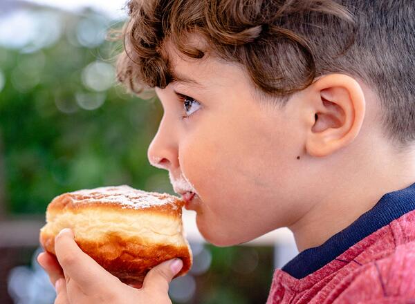 young person eating a donut