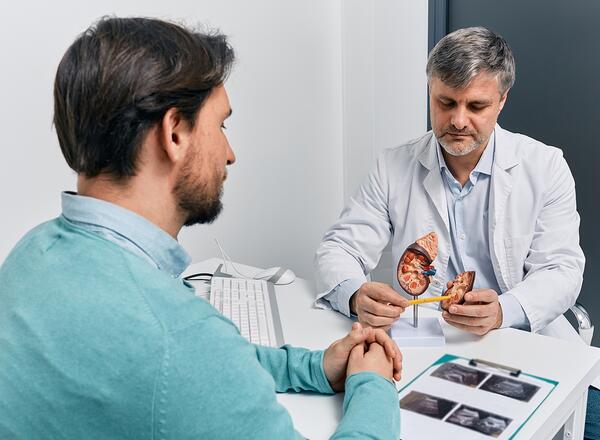Adult man during consultation with experienced urologist about his kidney disease and treatment at medical clinic. Kidneys health