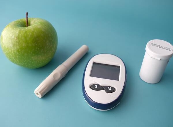 Apple and Glucose Monitor on Table