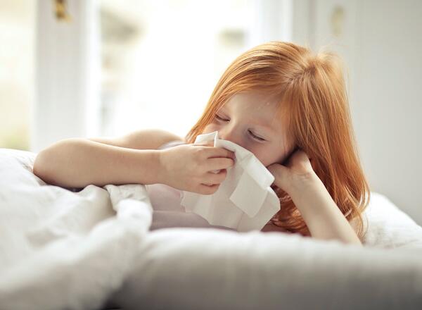 sick kid blowing her nose